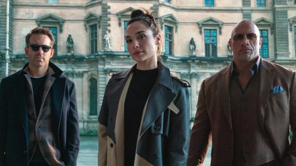 Dwayne Johnson, Gal Gadot e Ryan Reynolds em cena Alerta Vermelho.